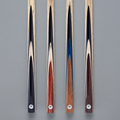 Four PRO147 ash cue designs on grey pool table cloth