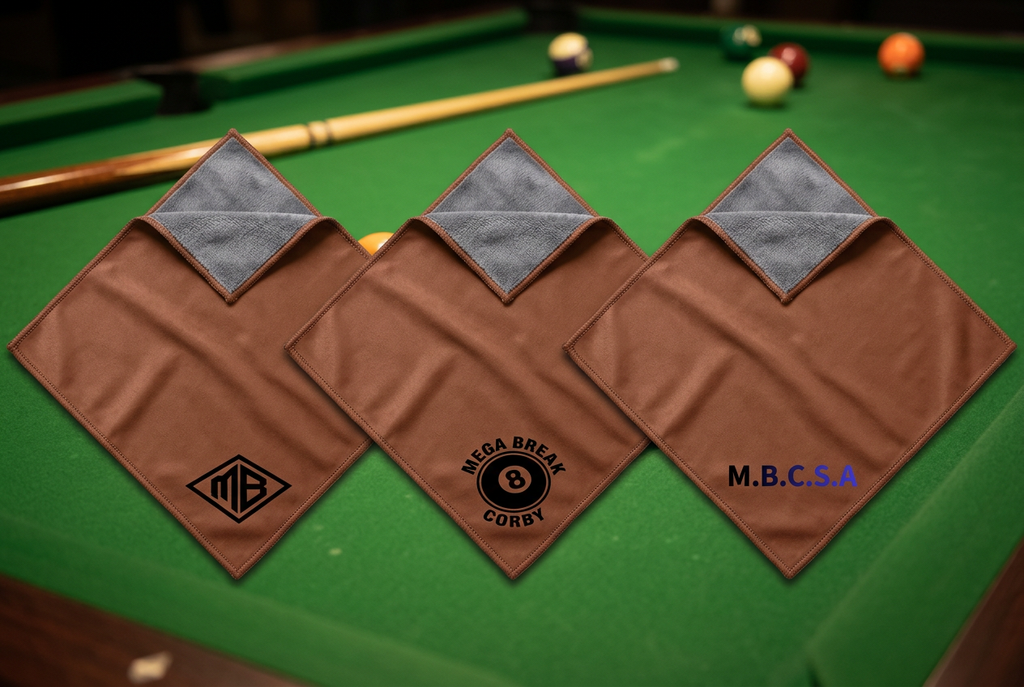 Three brown-and-grey cue cloths with corner logos on a pool table
